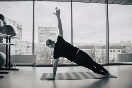 Indian man practicing yoga in doors, european city at backgroundの写真素材