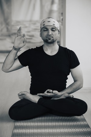 Indian man doing yoga practice indoors, full lotus meditation postureの写真素材