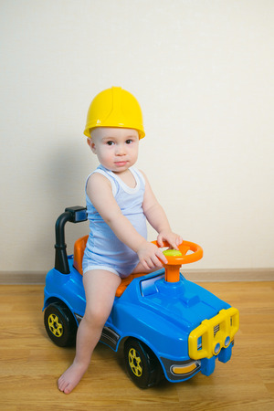 Cute Baby boy driving a toy car at homeの写真素材