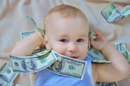 Cute baby boy playing with money, us dollars cashの写真素材
