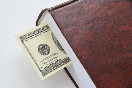 Dollar bill used as a bookmark in a bookの写真素材