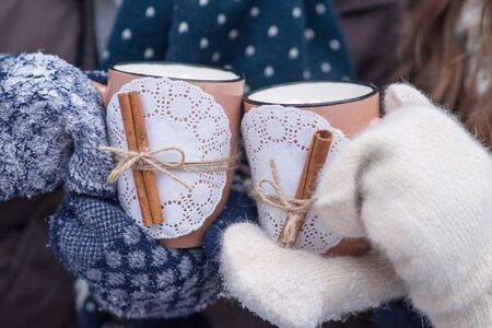 Young couple pours hot drink out of thermos, winter picnicの写真素材