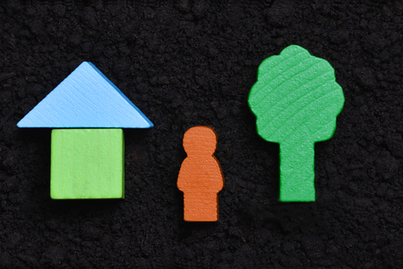To be a Man, build house, plant tree, father child. Wooden symbols on soil background.の写真素材