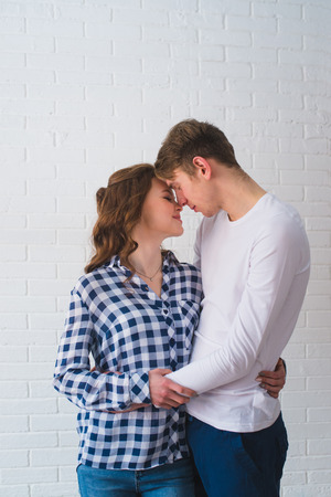 Studio Portrait Of Romantic Young Couple Embracing on a White Backgroundの写真素材