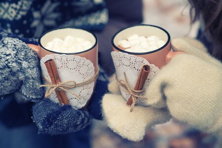 Young couple pours hot drink out of thermos, winter picnicの写真素材