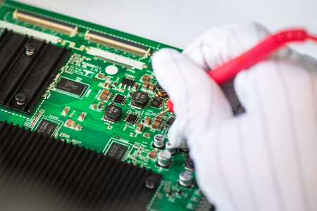 Computer repair service, hands of man tech testing motherboard with toolsの写真素材