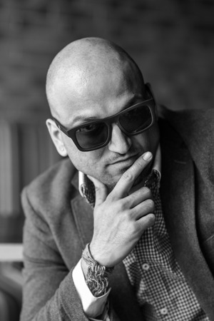 portrait of a hansome indian businessman wearing sunglasses, serious young man thinkingの写真素材