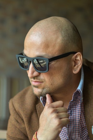 portrait of a hansome indian businessman wearing sunglasses, serious young man thinkingの写真素材