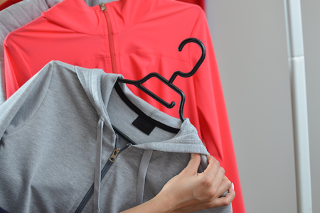 Woman hands picking a sports jacket in the shopの写真素材