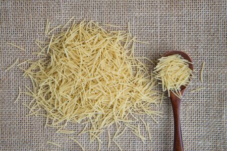 Filini raw pasta in wooden spoon on sack rustic background . Natural and healthy food conceptの写真素材