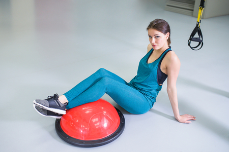 Sport woman exercise with a pilates ball at gym, smiling and looking at camera.の写真素材