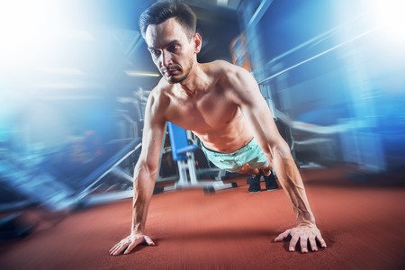 Handsome caucasian man working out and doing push ups at gym. Bodybuilding, sport and fitness...