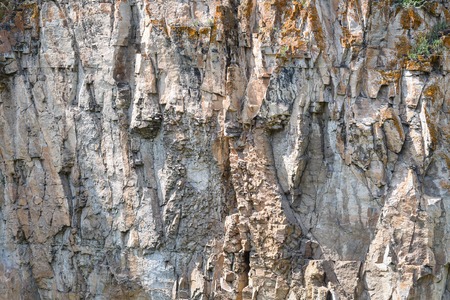 Detail closeup of a mountain rock wall, background or wallpaper of natural stone textureの写真素材
