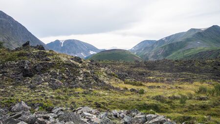 Frozen lava field in volcano valley with old Vulcan at background. Scenic landscape, Russia, Siberia.の写真素材