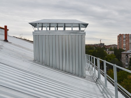 Metal corrugated roof with ventilation on apartment house house, closeup.の写真素材