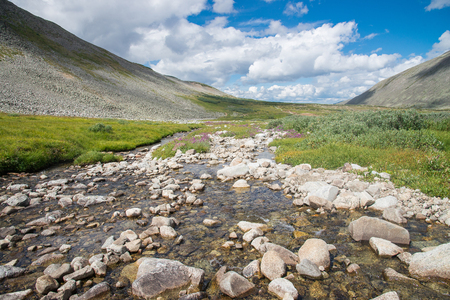 River in mountain valley blue cloudy sky at background. Natural summer landscape, Russia, Eastern Sayan mountains.の写真素材