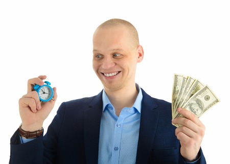 Excited Businessman with alarm clock and stack of cash in hand. Time is money concept.の写真素材
