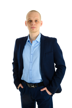 Serious Handsome caucasian man in blue suit standing and holding hands in pockets, isolated on white background.の写真素材