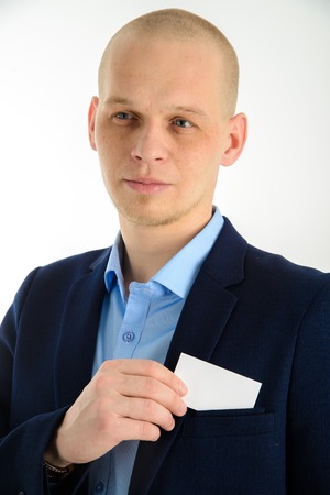 Businessman hand holding a business card over suit pocket, closeup. Isolated on white.の写真素材