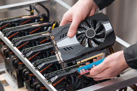 Mans hands connecting a new video card to mining farm. IT equipment. Cryptocurrency business.の写真素材