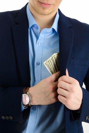 Businessman putting money in his suit pocket - closeup shotの写真素材