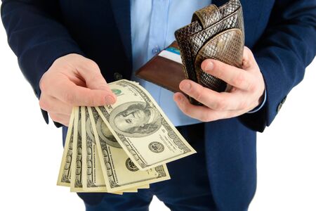 Businessman in suit takes out dollar from wallet, hand holding cash, closeup.の写真素材