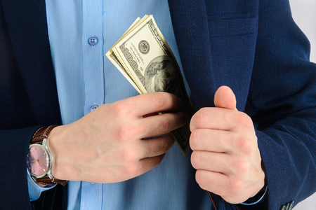Businessman putting money in his suit pocket - closeup shotの写真素材