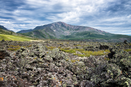 Frozen lava field in volcano valley with old Vulcan at background. Scenic landscape, Russia, Siberia.の写真素材