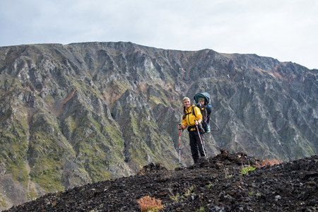 Woman Hiker trekking on mountain top with child in backpack . Summer leisure activity.の写真素材
