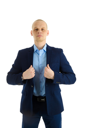 Serious Handsome young businessman in blue suit holding collar of a jacket, isolated on white background.の写真素材