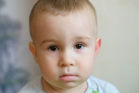 Sad little baby boy looking at camera. Caucasian child 2 years old. Closeup portriat.の写真素材