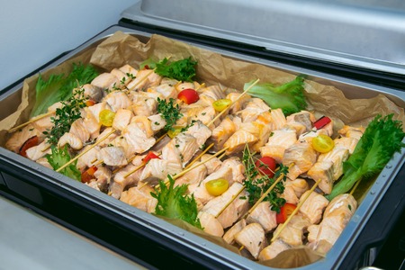 Big plate of shish kebab from slices of salmon roasted on a grill with vegetables. Catering service.の写真素材