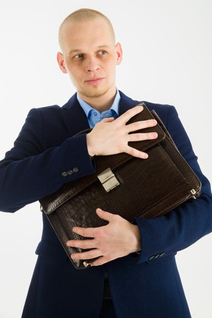 Handsome caucasian man in suit holding briefcase in hands on white background.の写真素材