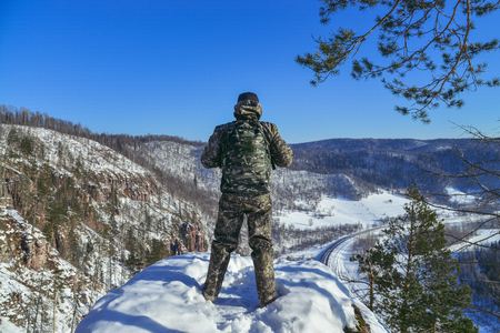 Back view of man hiker at mountain top in winter.の写真素材