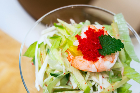 Salad with shrimp, red caviar, vegetables and greens. Seafood in restaurant. Closeup.の写真素材