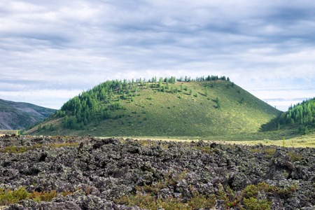 Frozen lava field in volcano valley with old Vulcan at background. Scenic landscape, Russia,...