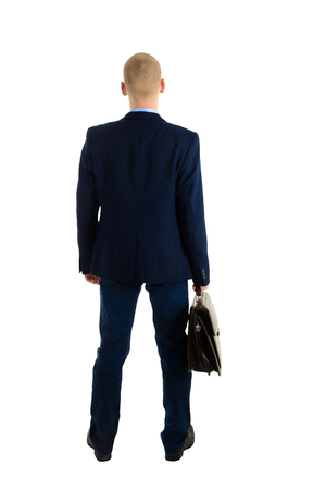 Businessman in suit with briefcase standing back isolated on white background, full length portrait.の写真素材