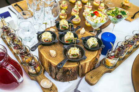 Beautiful catering banquet table with different food snacks and appetizers decorated for celebration party.の写真素材