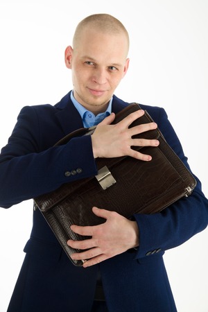 Wily caucasian man in suit holding briefcase in hands on white background.の写真素材