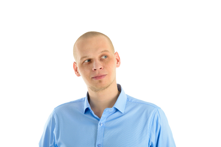 Handsome caucasian man in blue T-shirt looks thoughtfully up, isolated over white background.の写真素材