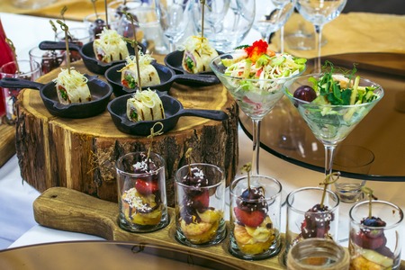 Beautiful catering banquet table with different food snacks and appetizers decorated for celebration party, closeup.の写真素材