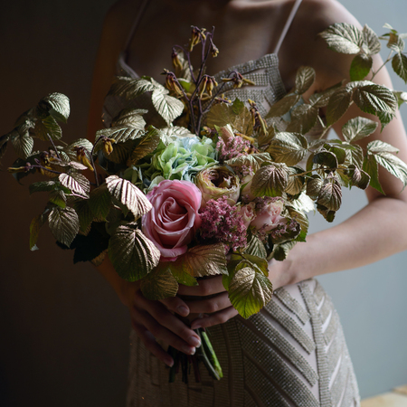 Woman hands holding beautiful decorated bouquet of flowers , closeup shoot.の写真素材