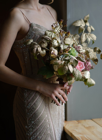 Woman hands holding beautiful decorated bouquet of flowers , closeup shoot.の写真素材