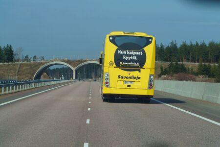 Helsinki nearest, Finland - April 29 2018: Yellow bus on road in Scandinavia. Highway to Helsinki on April 29, 2018.のeditorial素材