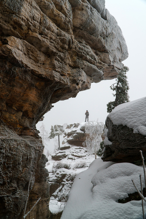 Man standing on rock in Famous national park Stone Town in winter, Russia, Perm region.の写真素材
