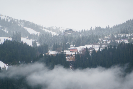 Norwegian landscape with typical scandinavian houses in mountains and forest covered with snow. Winter Scene.の写真素材