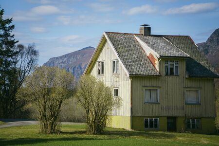 Norway - May 2, 2018: Old big wooden house near mountains at sunny day. Norway, spring timeのeditorial素材