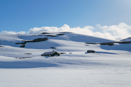 Wooden houses under snow in mountains, Spring in Norway, bright sunny day.の写真素材