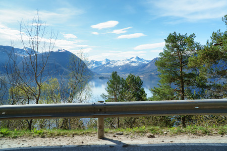 Norwegian spring landscape, view from road side near fjord, scenic mountains and blue sky at background.の写真素材