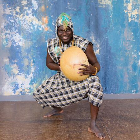 Handsome African man with traditional clothes and musical instruments